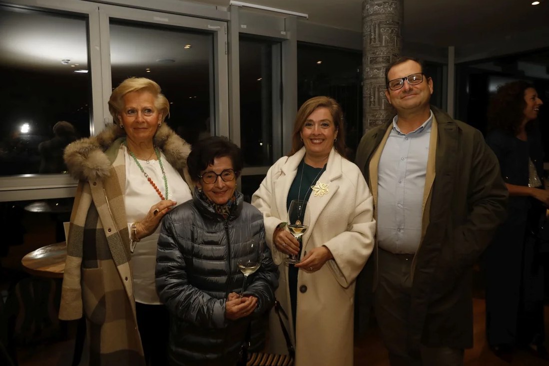 Cuatro asistentes posan junto a los ventanales del hotel.